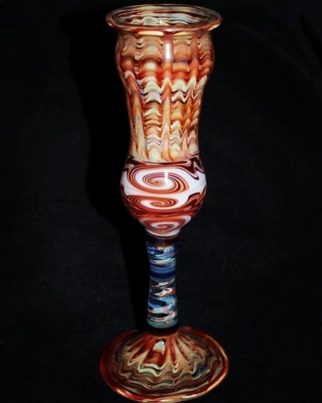 Flameworked goblet with amber and cream cane swirls, a marbled knop, and a blue-and-white twisted stem