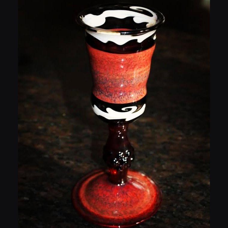 Red frit goblet with a white-and-black lace rim and a dark stem